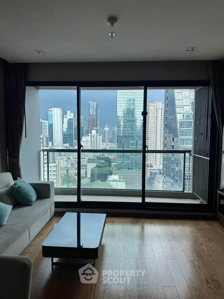 Stunning city view from modern living room with floor-to-ceiling windows and sleek furnishings.