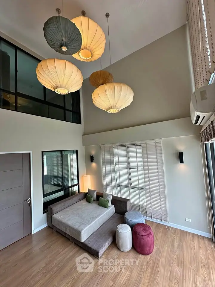 Spacious modern living room with high ceiling and stylish pendant lights