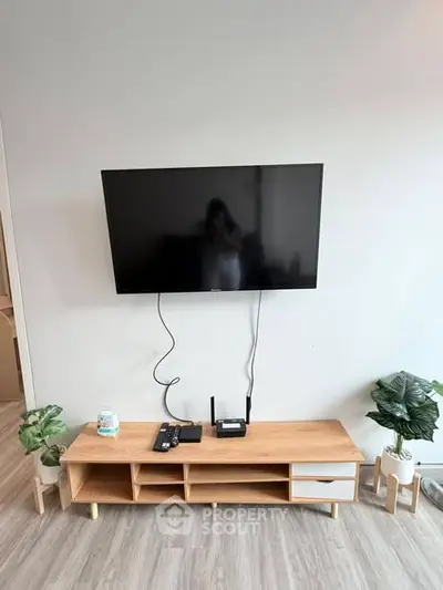 Modern living room with wall-mounted TV and stylish wooden console
