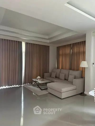 Modern living room with sleek design, featuring a comfortable sectional sofa and elegant floor lamp.