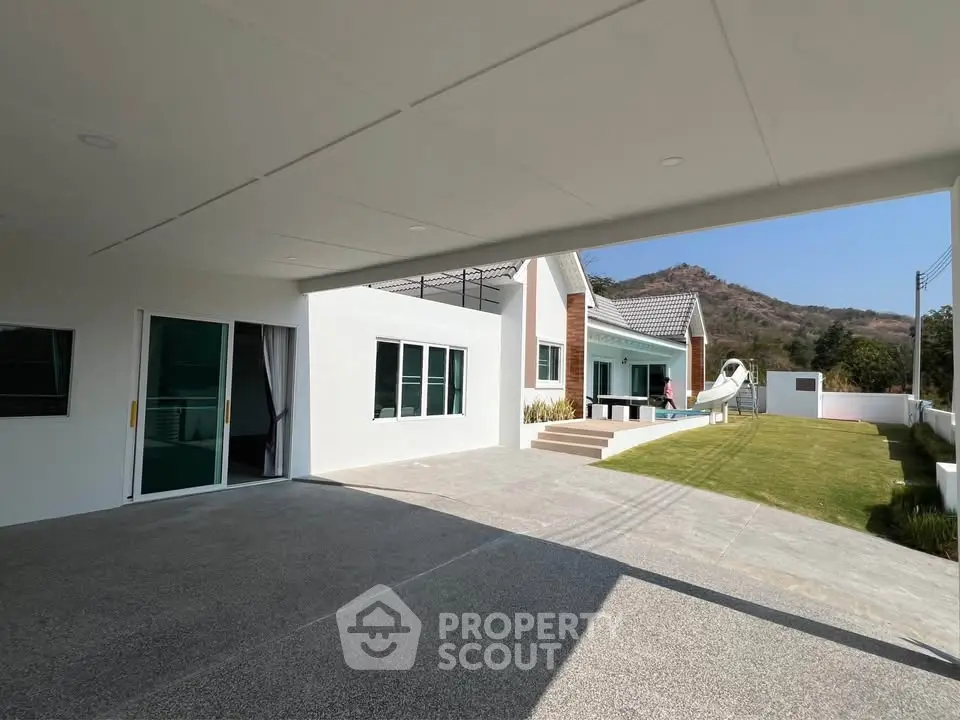 Modern white house with spacious driveway and scenic mountain view