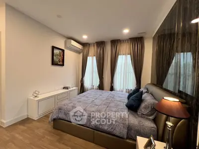 Luxurious bedroom with elegant decor and ample natural light, featuring a cozy bed and stylish furnishings.