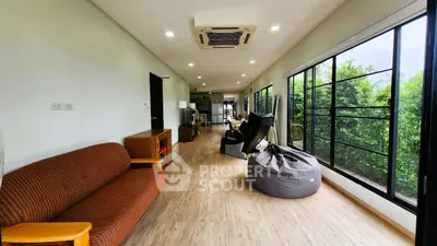 Spacious living room with modern decor and large windows offering garden views.