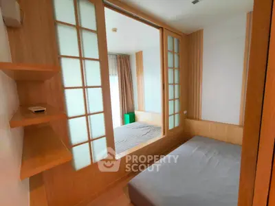 Modern bedroom with wooden accents and sliding glass doors, offering a cozy and stylish living space.