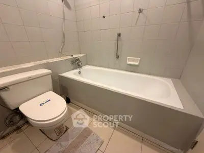 Spacious bathroom with bathtub and modern fixtures, ideal for relaxation.