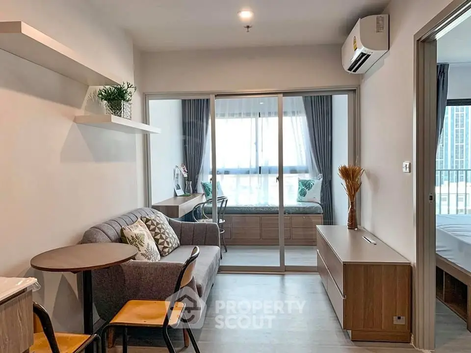 Modern living room with cozy seating and natural light in a stylish apartment.