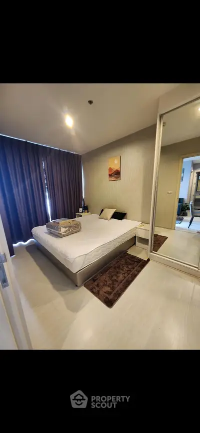 Modern bedroom with stylish decor and large mirror wardrobe