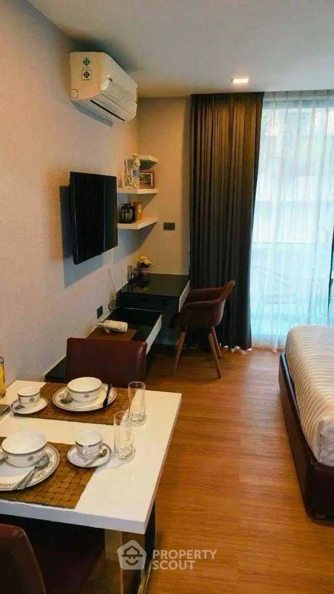 Modern studio apartment with stylish decor, featuring a cozy dining area and comfortable bed.