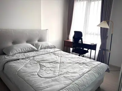 Modern bedroom with cozy bed and study desk near window, perfect for relaxation and productivity.