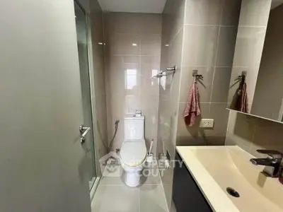 Modern bathroom with sleek fixtures and glass shower enclosure in a contemporary apartment.