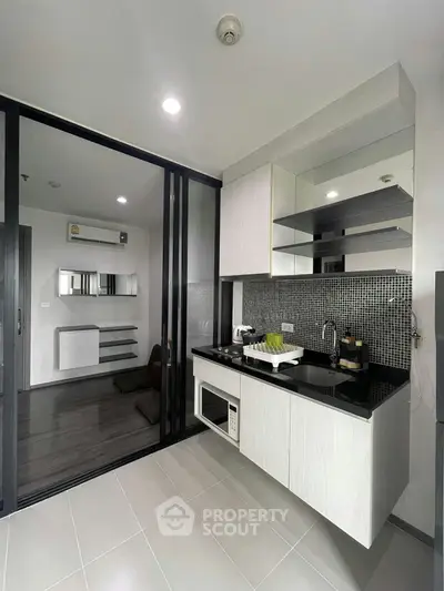 Modern kitchen with sleek design and open layout, featuring built-in appliances and stylish backsplash.