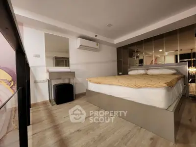 Modern bedroom with mirrored wall and sleek design, featuring a comfortable bed and stylish decor.