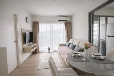 Modern living room with stylish decor and dining area, featuring large windows and natural light.