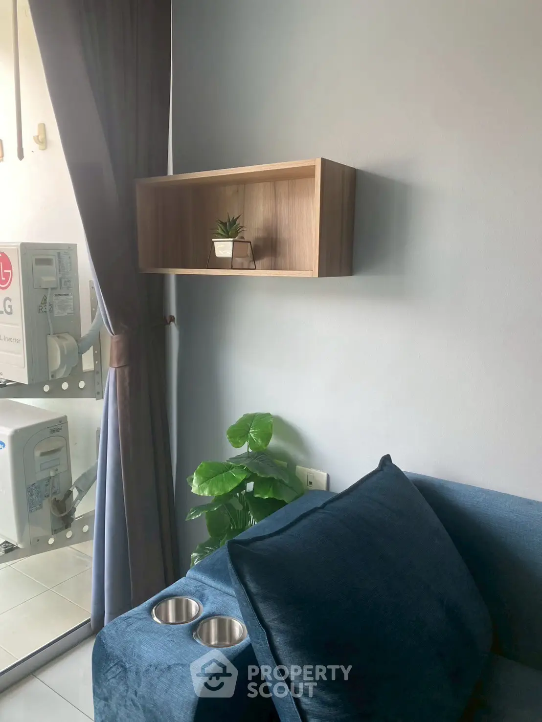 Cozy living room with modern blue sofa and stylish wall shelf