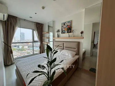 Modern bedroom with city view, featuring stylish decor and large windows for natural light.