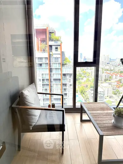Modern balcony with city view, featuring sleek furniture and large windows for natural light.