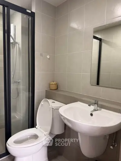 Modern bathroom with sleek shower and elegant fixtures in contemporary apartment.