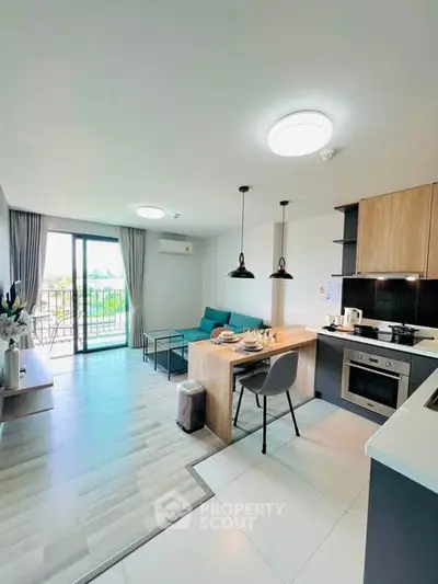 Modern open-layout living room with kitchen and balcony view