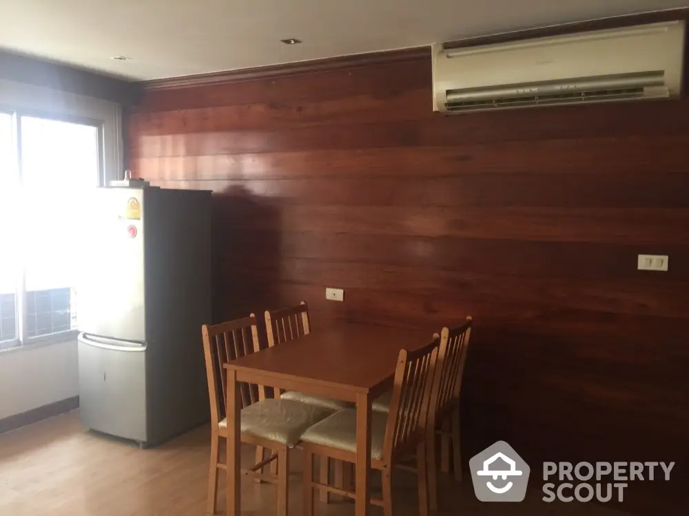 Cozy dining area with wooden wall and air conditioning in modern apartment