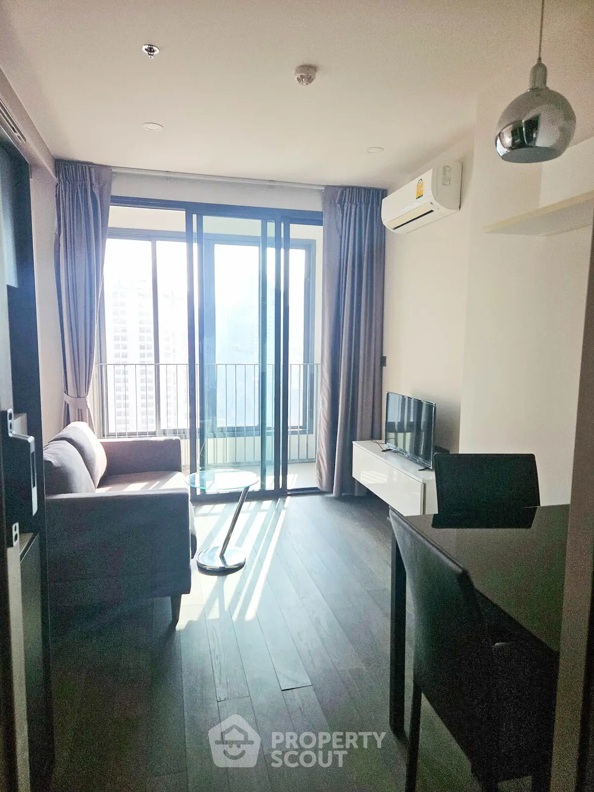 Modern living room with balcony and city view in high-rise apartment