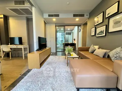 Modern living room with stylish decor and open layout, featuring a cozy sofa and elegant wall art.