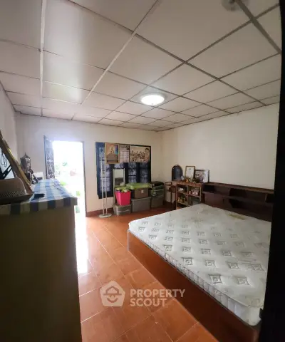Cozy bedroom with tiled floor and ample natural light, featuring a comfortable bed and organized storage solutions.