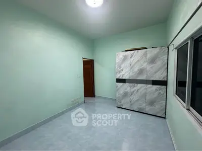 Spacious bedroom with modern wardrobe and large windows