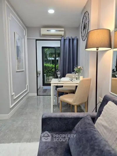 Modern living room with stylish decor and dining area, featuring elegant lighting and garden view.