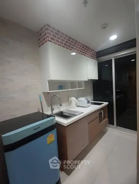Modern kitchen with sleek appliances and stylish cabinetry in a cozy apartment setting.
