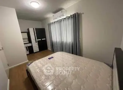 Modern bedroom with sleek wardrobe and air conditioning in a cozy apartment.