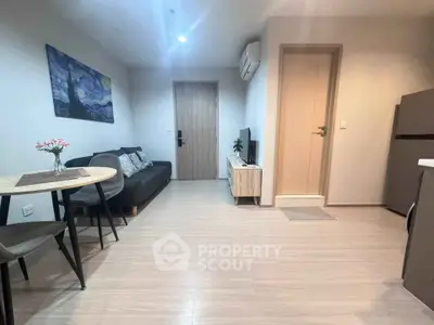 Modern living room with stylish decor and compact dining area in a cozy apartment.