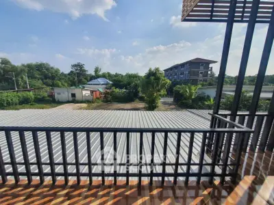 Spacious balcony with scenic view of lush greenery and modern building