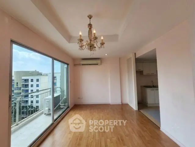 Spacious living room with chandelier and balcony view in modern apartment