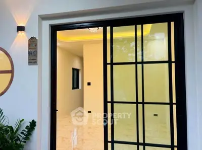 Modern sliding glass door entrance with elegant interior lighting and marble flooring.