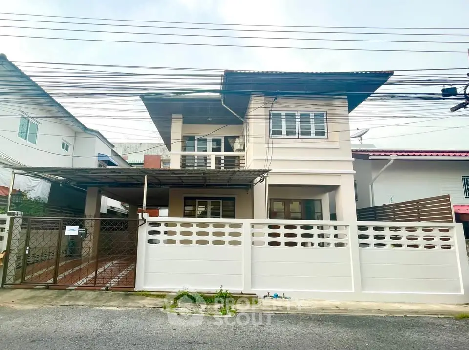 Charming two-story house with gated entrance and modern facade in a serene neighborhood.