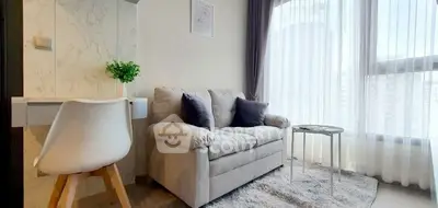 Modern living room with cozy sofa, stylish decor, and large window for natural light.