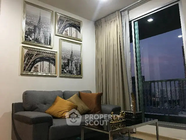 Stylish living room with modern decor and city view balcony at dusk.