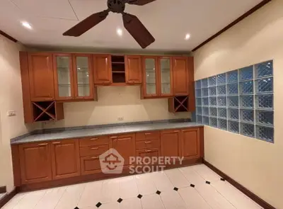 Spacious kitchen with wooden cabinets and glass block wall