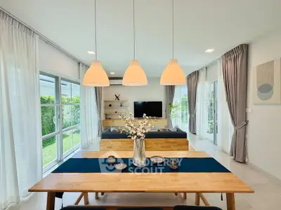 Spacious modern living room with elegant dining area and garden view, perfect for family gatherings.