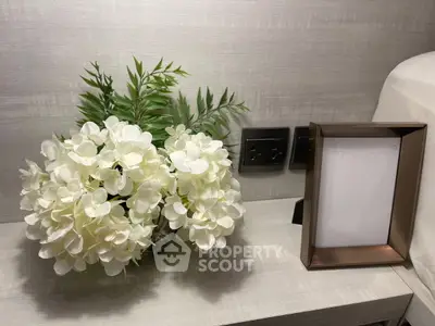Elegant bedroom nightstand with floral arrangement and empty photo frame
