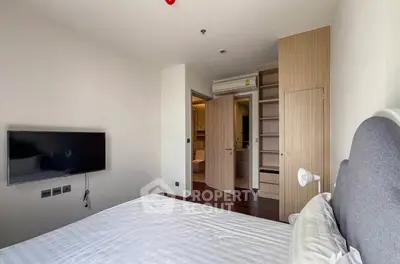 Modern bedroom with built-in wardrobe and wall-mounted TV in a stylish apartment.