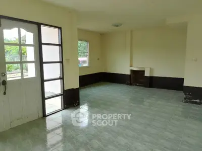Spacious empty living room with large windows and tiled flooring