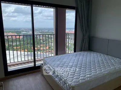 Spacious bedroom with stunning city view from large windows, featuring a comfortable bed.