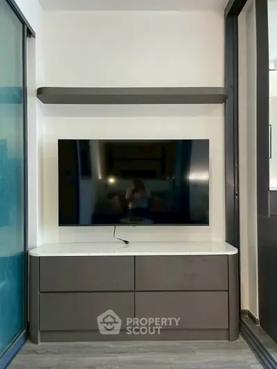 Modern living room with sleek TV unit and floating shelf, perfect for contemporary homes.