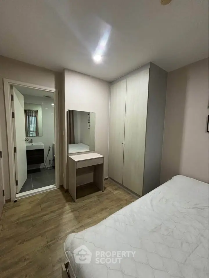 Cozy bedroom with ensuite bathroom and modern wardrobe in stylish apartment.