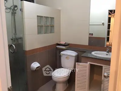 Modern bathroom with glass shower and sleek vanity in a cozy home.