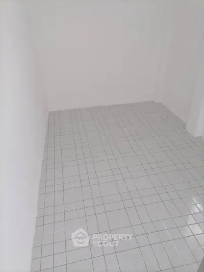 Spacious empty room with tiled flooring, perfect for customization and design.