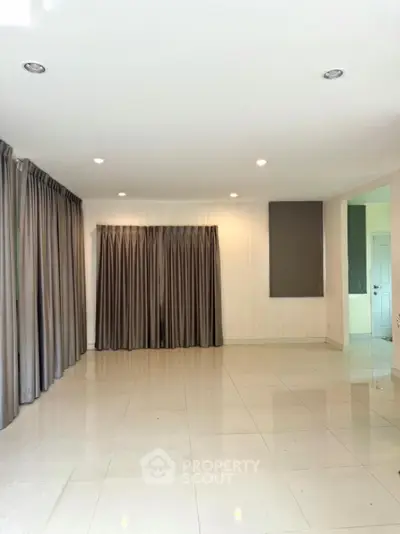 Spacious empty living room with elegant curtains and glossy tiled floor