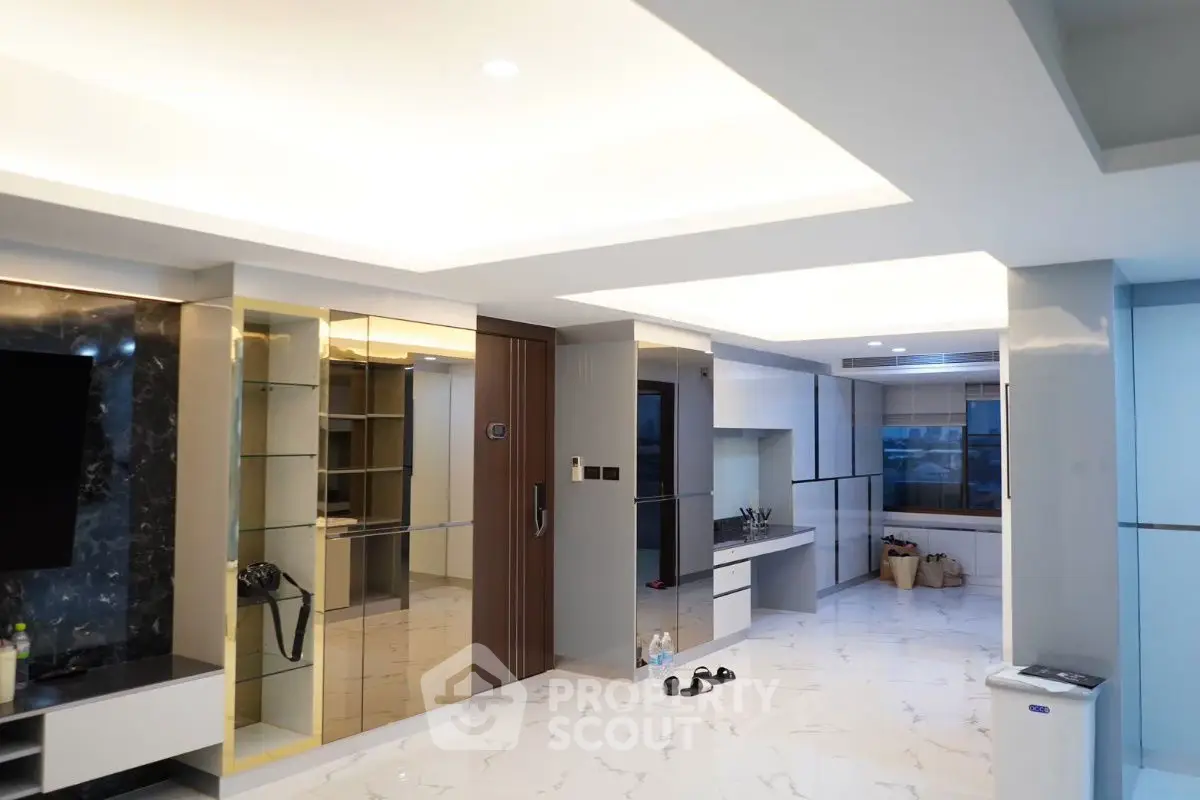 Spacious modern living room with elegant marble flooring and sleek built-in storage.