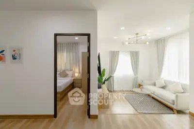 Modern open-concept living room with natural light and cozy bedroom view.